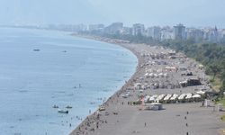 Antalya'da turistler serinlemek için denize giriyor