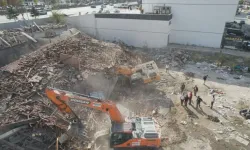 Kontrollü yıkım yapan kepçe, binanın altında kaldı